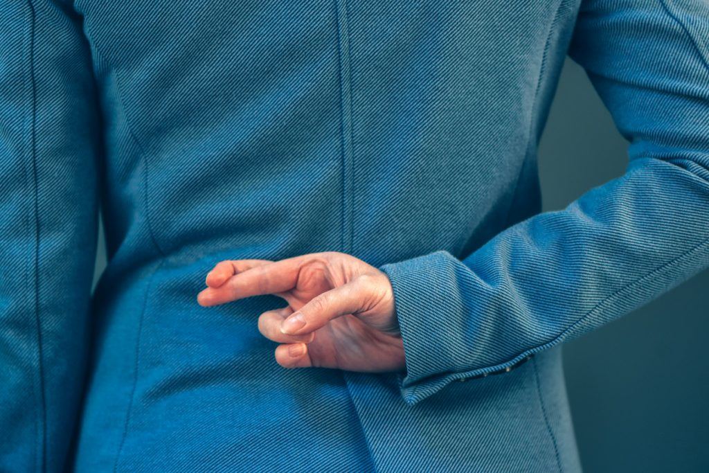 Business woman has crossed fingers behind her back He Said, She Said……but she lied!