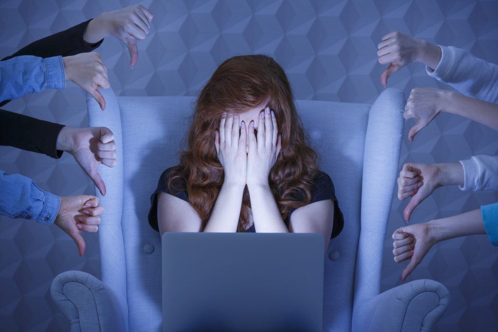 Girl with laptop covering face Ask Carolyn: Is Humiliation Grounds for Divorce?