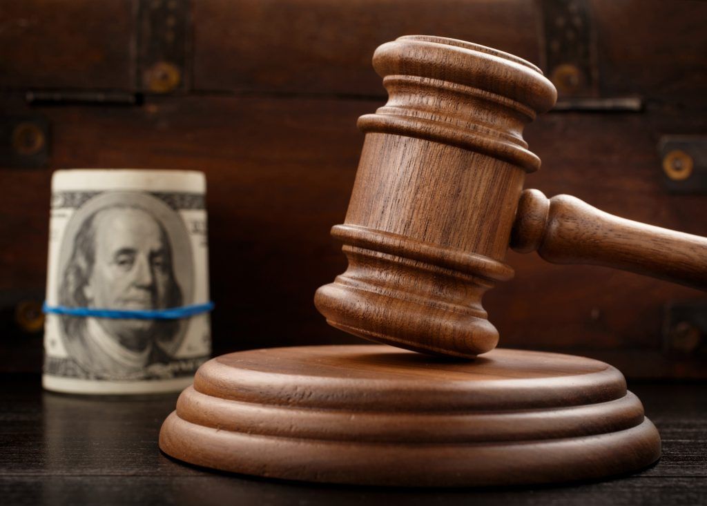 Judge gavel and bundle of hundred-dollar bills Ask Carolyn: Is My Ex Cohabiting? Will that Terminate My Alimony?