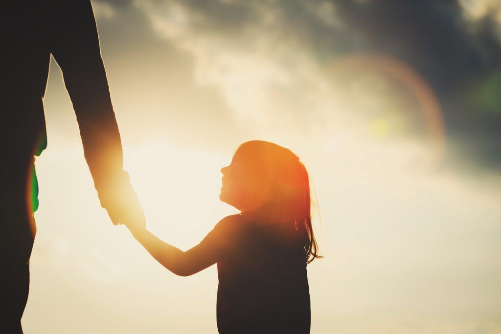silhouette of little girl holding parent hand at sunset How I Built a Close Father-Daughter Relationship After Divorce