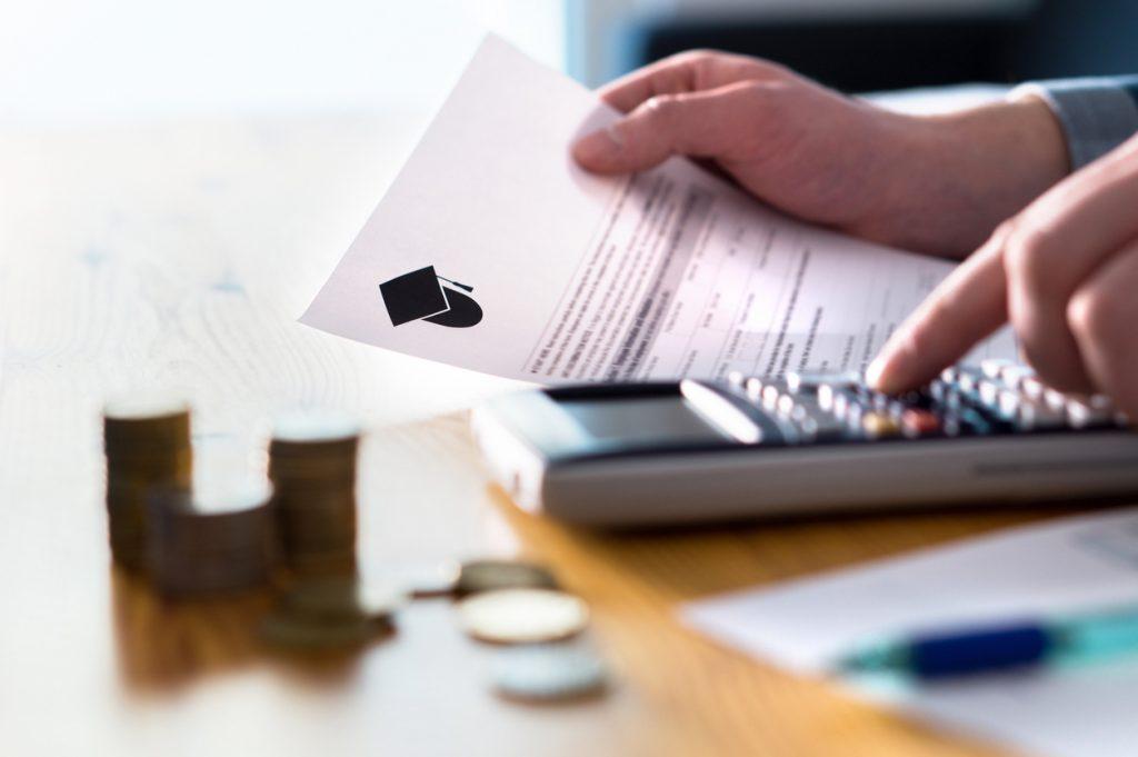Man counting college savings fund, tuition fee or student loan with calculator. Education price and expenses concept. Money and papers on table. Are 529 Savings Plans Legally Considered a Gift to Children in North Carolina?